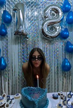 a woman sitting in front of a birthday cake