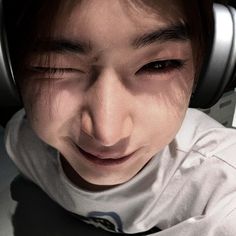 a close up of a person wearing headphones and looking at the camera with an intense look on their face