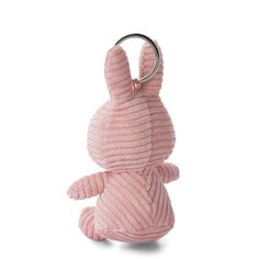 a pink stuffed animal with a ring on it's neck, sitting in front of a white background