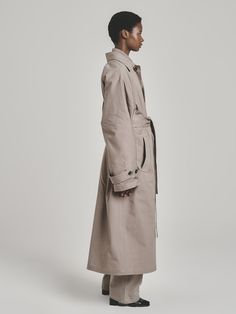 When it comes to great style, you can never go wrong with an elevated classic. UNI FORM’s trench coat has an enveloping oversized profile, concealed button closure, and comfortable raglan sleeves. Cut from midweight cotton twill in a versatile taupe hue, it also features adjustable cuffs and a back tab, adding definition to the relaxed shape. Use the removable belt to cinch the waist. - Pointed collar, concealed button fastening, buttoned tabs at cuffs, welt pockets, back tab, self-tie belt, bac Oversized Belted Cotton Outerwear, African Luxury, Soft Tailoring, Cotton Crafts, Utility Pants, Summer Staples, Welt Pocket, African Fashion, Raglan Sleeve