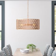 a dining room table with chairs and a chandelier hanging from the ceiling