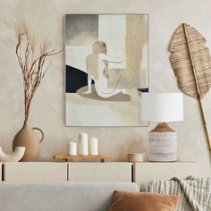 a living room scene with focus on the couch and art hanging above the sofa table