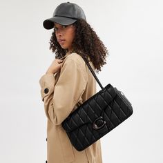 A modern take on an archival 1970s Coach design our structured Tabby shoulder bag is crafted of luxe quilted nappa leather. Finished with our Signature hardware for an iconic touch the 33 is a spacious style with a secure inside zip pocket a convenient outside pocket and plenty of room for essentials including a mini tablet. Keep the leather-and-chain strap long to wear it crossbody or double it for a shorter dressier look. | Coach Tabby Shoulder Bag 33 With Quilting - Women's - Pewter/black Coach Bag Blck, Coach Bags 2021, Coach Handbags Coach, Trendy Coach Shoulder Bag, Coach Pillow Tabby Purse, Coach Hamdbags, Luxury Handbags Coach, Coach Bags Handbags Coach, Black Crossbody Bag Coach