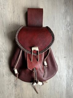 a brown leather pouch with chains hanging from it