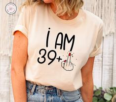 a woman wearing a t - shirt that says i am 39 plus with a hand pointing up