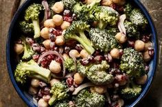 a bowl filled with broccoli and chickpeas on top of a wooden table