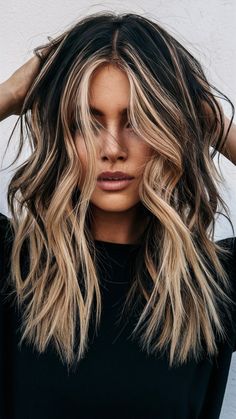 This layered hairstyle features long, textured layers with striking blonde face-framing highlights on a dark base. The contrast adds dimension and brightness, perfectly complementing the soft waves. Ideal for those seeking bold long layers with a modern edge. Highlights With Blonde Bangs, Dark Hair Blonde Peekaboo, Bold Face Framing Highlights, Face Framing Blonde On Dark Hair, Blonde Peaks Boo Highlights, Blond Roots Dark Ends, 90s Long Layered Hair Face Framing, Bright Blonde Highlights On Dark Hair, Highlights On Top Of Hair Only