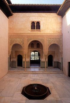 an empty courtyard with a fountain in the middle