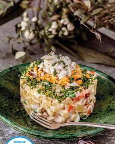 a close up of a plate of food on a table with flowers in the background