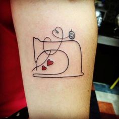 a tattoo on the arm of a woman with hearts and a sewing machine in it