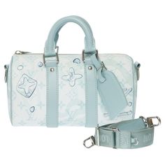 The Keepall Bandoulière 25 is fashioned from Monogram Aquagarden canvas, in which the LVs and Monogram Flowers appear to be covered by drops of water. The three-dimensional waterdrop effect is achieved with an innovative inkjet technique. This small bag features all the signature Keepall details, including the two lateral reinforcement bands and the leather name tag. Product details Dimensions: 25x15x11cm (9,8x5,9x4,3 Inches) Crystal Blue Monogram Aquagarden coated canvas Cowhide-leather trim Textile lining Silver-color hardware Zip closure Main compartment Removable name tag Inside flat pocket Strap:Removable, adjustable Strap drop: 21.7 inches Strap drop max: 24.8 inches Handle:Double Reference: 101385 General condition: 8/10 Sold with removable shoulder strap, label reference and dustba Sac Louis Vuitton, Drops Of Water, Louis Vuitton Speedy 25, Blue Purse, Leather Label, Crystal Blue, Louis Vuitton Speedy, Inspiration Mode, Name Tag