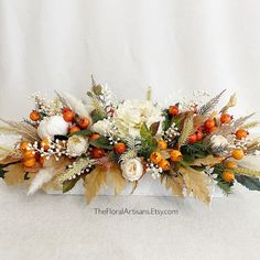 an arrangement of white flowers and orange berries