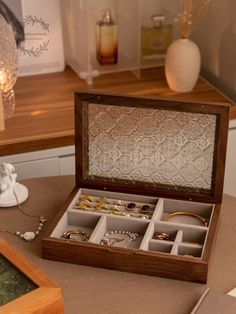 an open wooden jewelry box sitting on top of a table