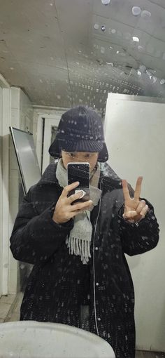 a person taking a selfie in front of a mirror with water droplets on it