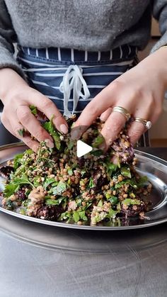 a woman is preparing food on a silver plate