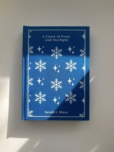 a blue book with white snowflakes on it sitting on top of a table