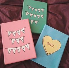 three painted canvass with hearts and bunting on them, one has an applique