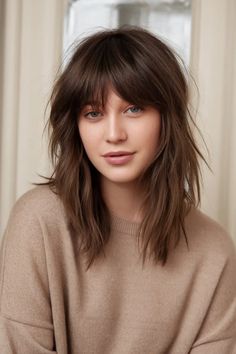 Person with long, layered brown hair and bangs, wearing a beige sweater, smiles softly. Mid Length Shag Haircut, Shag Cut Straight Hair, Mid Length Shag, Shag Cut With Bangs, Haircuts Medium Length, Best Hair Cut, Shag Haircut Ideas, Long Haircuts With Bangs, Thick Bangs