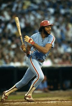 a baseball player holding a bat on top of a field in front of a crowd