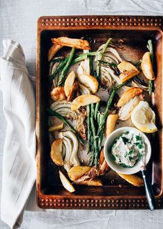 an overhead view of some food on a wooden tray with a white cloth and napkin