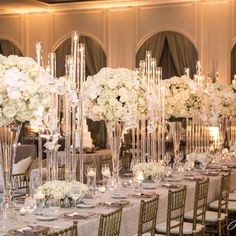 an elegant wedding reception with tall centerpieces and white flowers