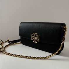 Authentic New Tory Burch Britten Chain Wallet/ Crossbody With Wristlet Color Black And Gold Brand New With Tag. Length: 8' (20.3 Cm) Height: 4.75" (14 Cm) Depth: 1.5" (3.8 Cm). With 6 Card Holders. Fits An Iphone 15 Pro Max. We Ship The Same Day. Classic Clutch With Gold-tone Hardware As Gift, Black Rectangular Wallet With Chain Strap, Black Rectangular Wallets With Chain Strap, Classic Black Wallet On Chain, Elegant Rectangular Wallet As Fashion Accessory, Elegant Rectangular Fashion Wallet, Black Rectangular Wallet On Chain With Gold-tone Hardware, Elegant Black Wallet, Elegant Tan Wallet On Chain With Gold-tone Hardware