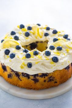 a blueberry bunt cake with white frosting and fresh blueberries on top