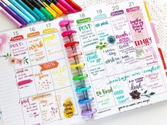 an open planner with markers and stickers on the pages, next to some crayons