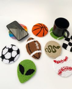 crocheted coasters with sports balls on them and a cell phone in the background