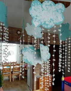 some blue and white paper clouds hanging from the ceiling in a kitchen or dining room