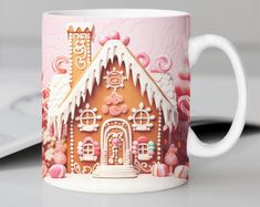 a pink and white coffee mug with a gingerbread house on it