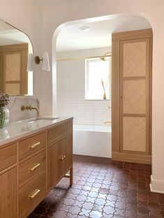 a bathroom with a sink, mirror and bathtub next to an archway in the wall