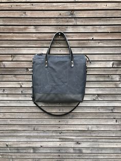 Black canvas leather tote bag made for daily use to take with you everywhere, also the office, smart enough for any occasion The bag is constructed out of heavy weight waxed canvas in black with a bottom in leather, closing with a zipper. There is an outside pocket with rounded edges closing with a snap on one side Handles and cross body strap are made in vegetable tanned leather. Inside the bag is lined with cotton canvas with a padded laptop compartment and on the other side a double slip pock Canvas Leather Tote Bag, Canvas Leather Tote, Diaper Bag Tote, Work And Travel, Bicycle Bag, Travel Tote Bag, Messenger Bag Men, Leather Work, Waxed Canvas