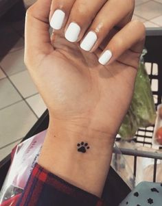 a woman's hand with a small paw print on it and a shopping cart in the background