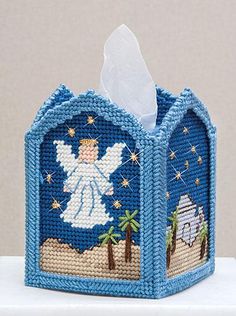 a blue tissue box with an angel on it's side and a palm tree in the background