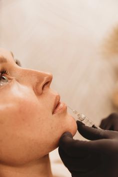 a woman getting her nose examined by a doctor