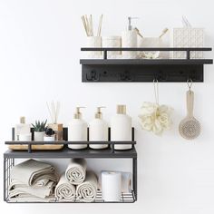 two black shelves with towels, soaps and other items on them in a bathroom