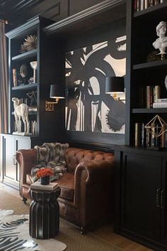 a living room filled with furniture and bookshelves next to a wall mounted book case