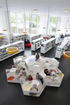 an aerial view of a library with people sitting in the chairs and bookshelves