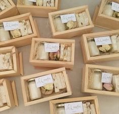 there are many small wooden boxes with candles in them that have labels attached to them