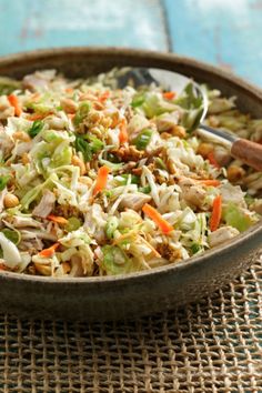 a bowl filled with coleslaw and carrots on top of a table