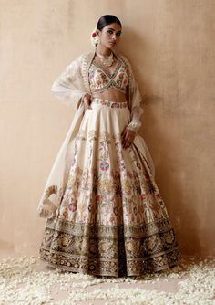 Editor's Note Presenting an opulent ivory raw silk lehenga set adorned with intricate floral thread embroidery and sumptuous velvet patchwork, elegantly highlighted with various embellishments.... Traditional Hand Embellished Cream Sets, Traditional Cream Hand-embellished Sets, Cream Bollywood Lehenga With Floral Embroidery, Traditional Drape Sets With Floral Embroidery In Cream, Cream Sets With Floral Embroidery And Traditional Drape, Cream Floor-length Sets With Intricate Embroidery, Off White Raw Silk Set With Intricate Embroidery, Cream Embroidered Raw Silk Sets, Festive Cream Lehenga With Floral Embroidery