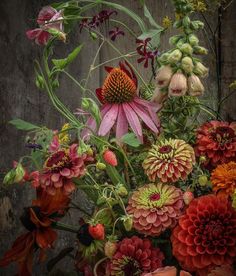 a vase filled with lots of flowers on top of a table