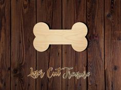 a wooden sign that says laser cut treasure with a dog bone on it's side