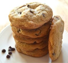 a stack of chocolate chip cookies sitting on top of a white plate