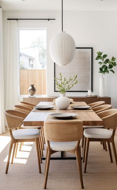 a dining room table with chairs, plates and vases on top of the table