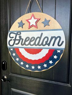 a wooden sign that says,'freedom'hanging on a door with stars and stripes