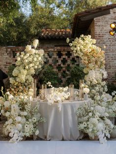 a table with white flowers and candles on it