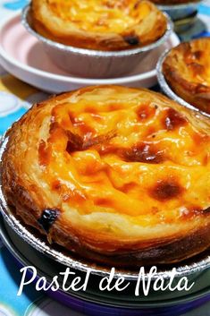 three pies sitting on top of each other in tin pans next to plates