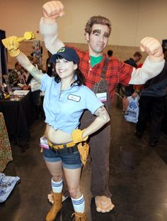 a man and woman dressed up in costumes at a convention or show, posing for the camera